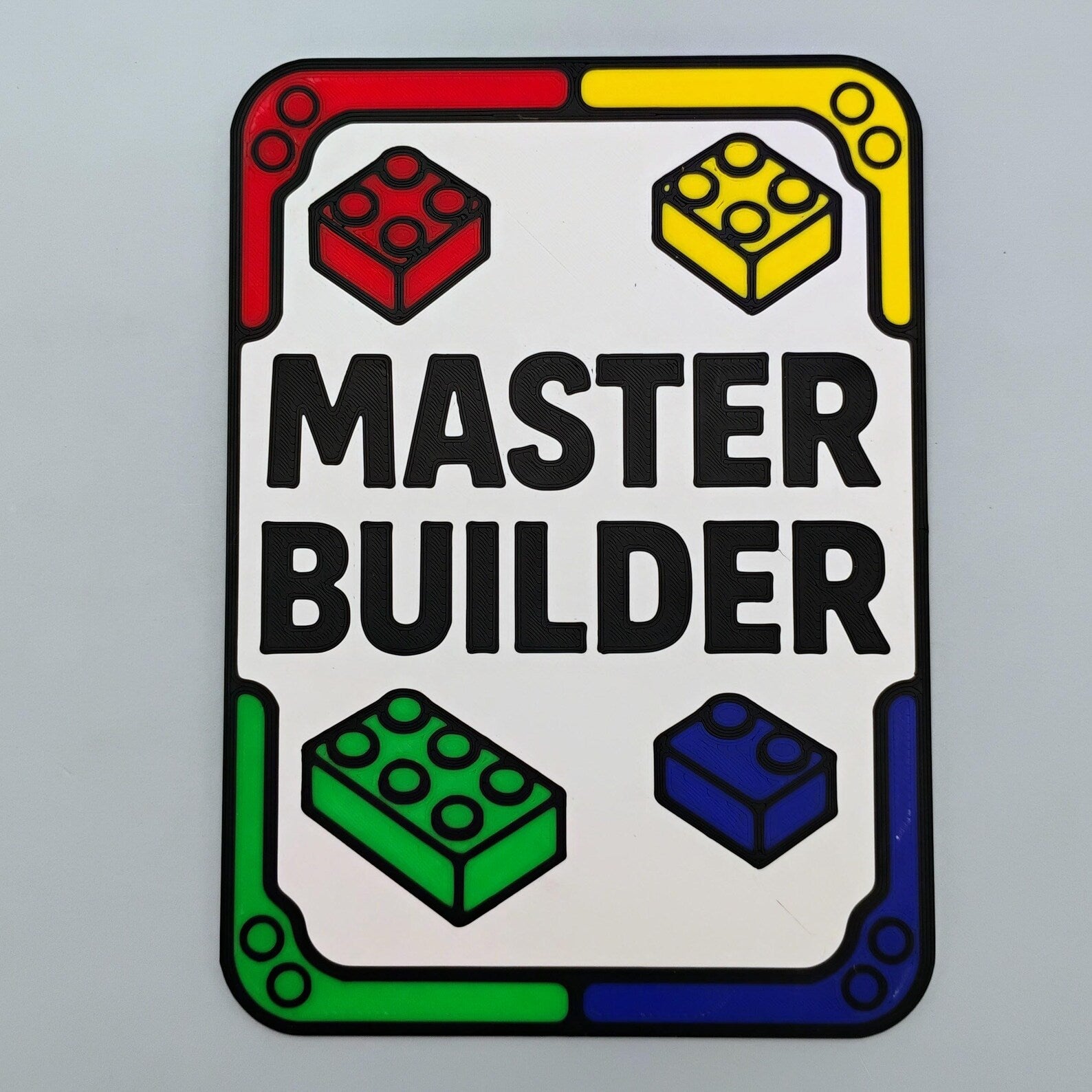 Master Builder sign with red yellow green and blue brick design around the border