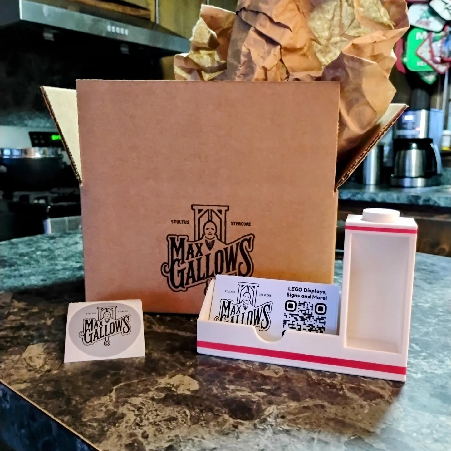 Business card holder shown with Max Gallows packaging and included display pieces