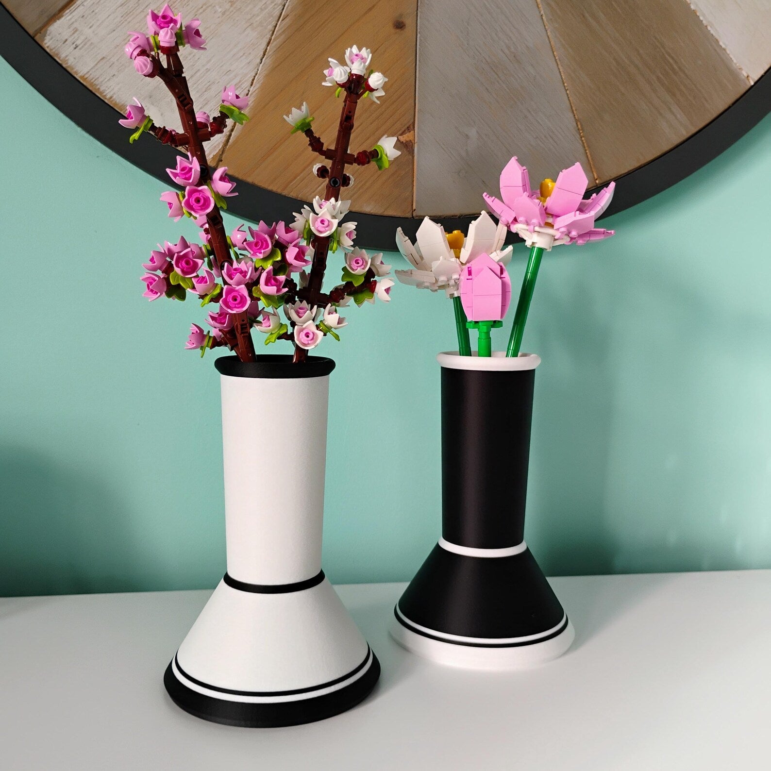 Black and white minimalist vases holding LEGO® botanical flowers with removable stem grid inserts