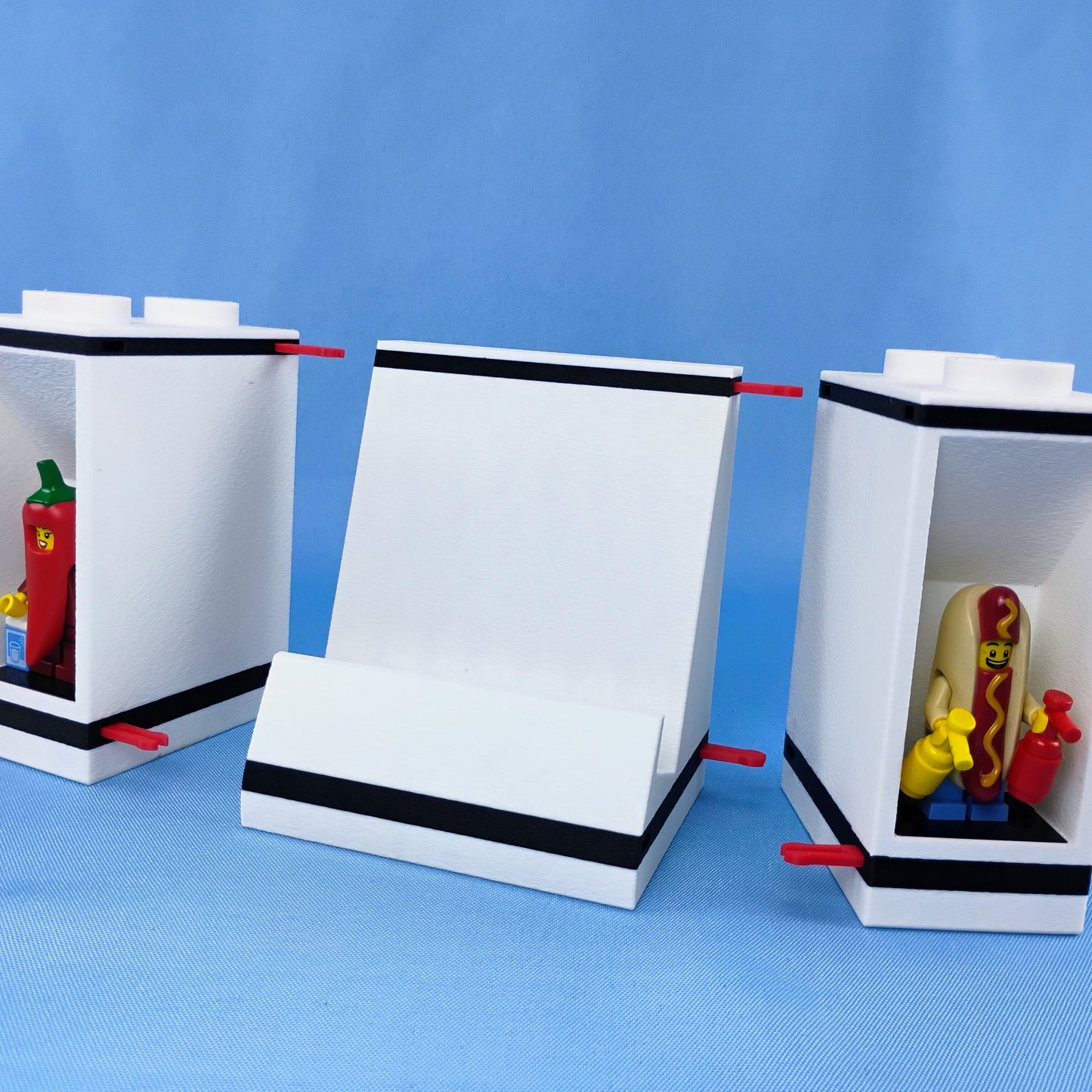 Phone stand and LEGO® minifigure display modules shown separated to demonstrate how the modular pieces connect together.