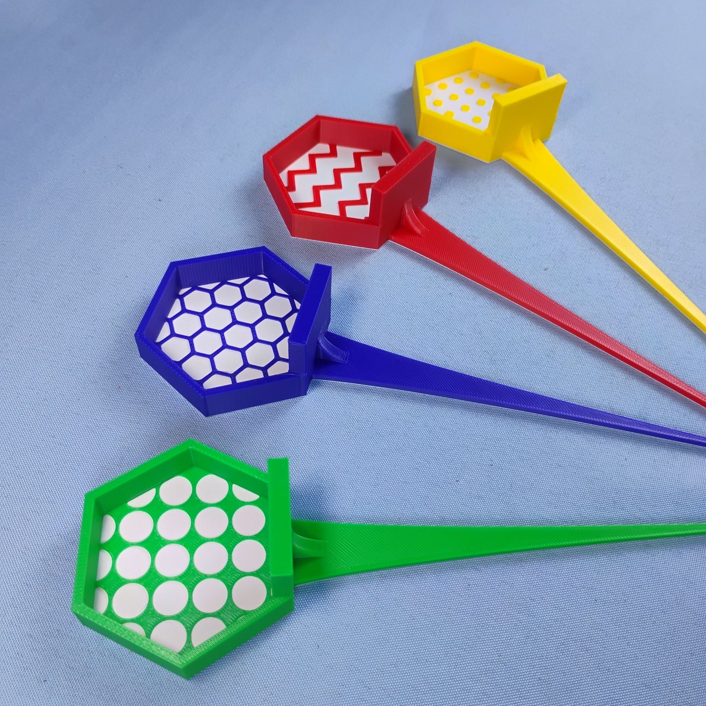Red, yellow, blue and green LEGO® minifigure garden stakes with four different patterned display backgrounds.