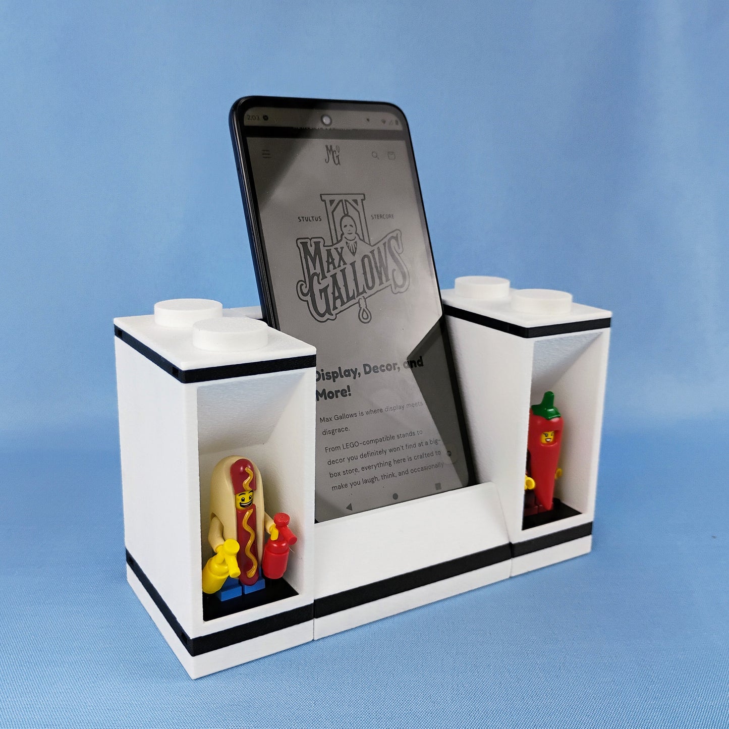 Angled view of a white phone stand with two LEGO® minifigure display bricks and colorful minifigures.