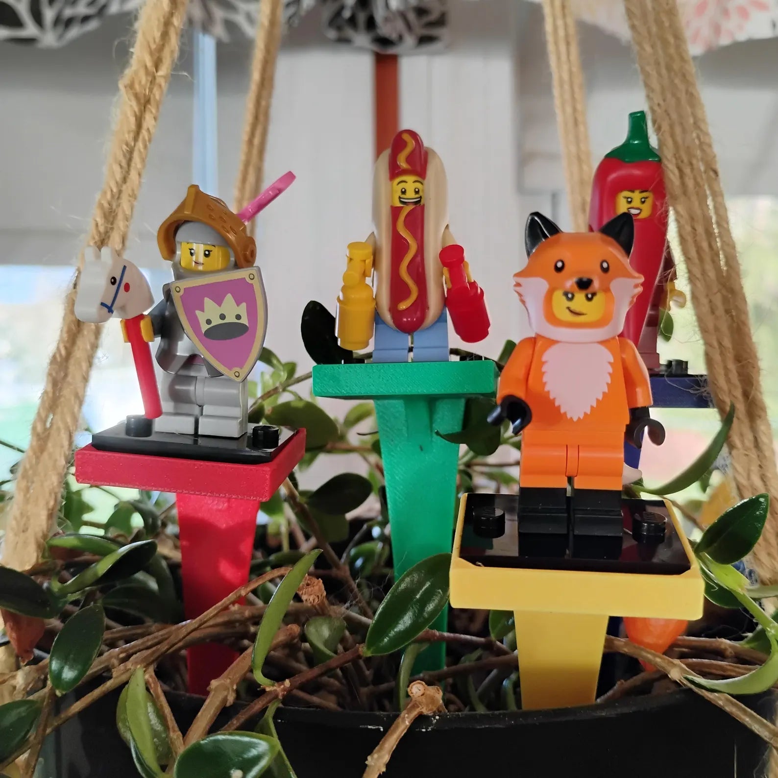 Colorful plant stakes with LEGO® minifigures displayed in a hanging plant