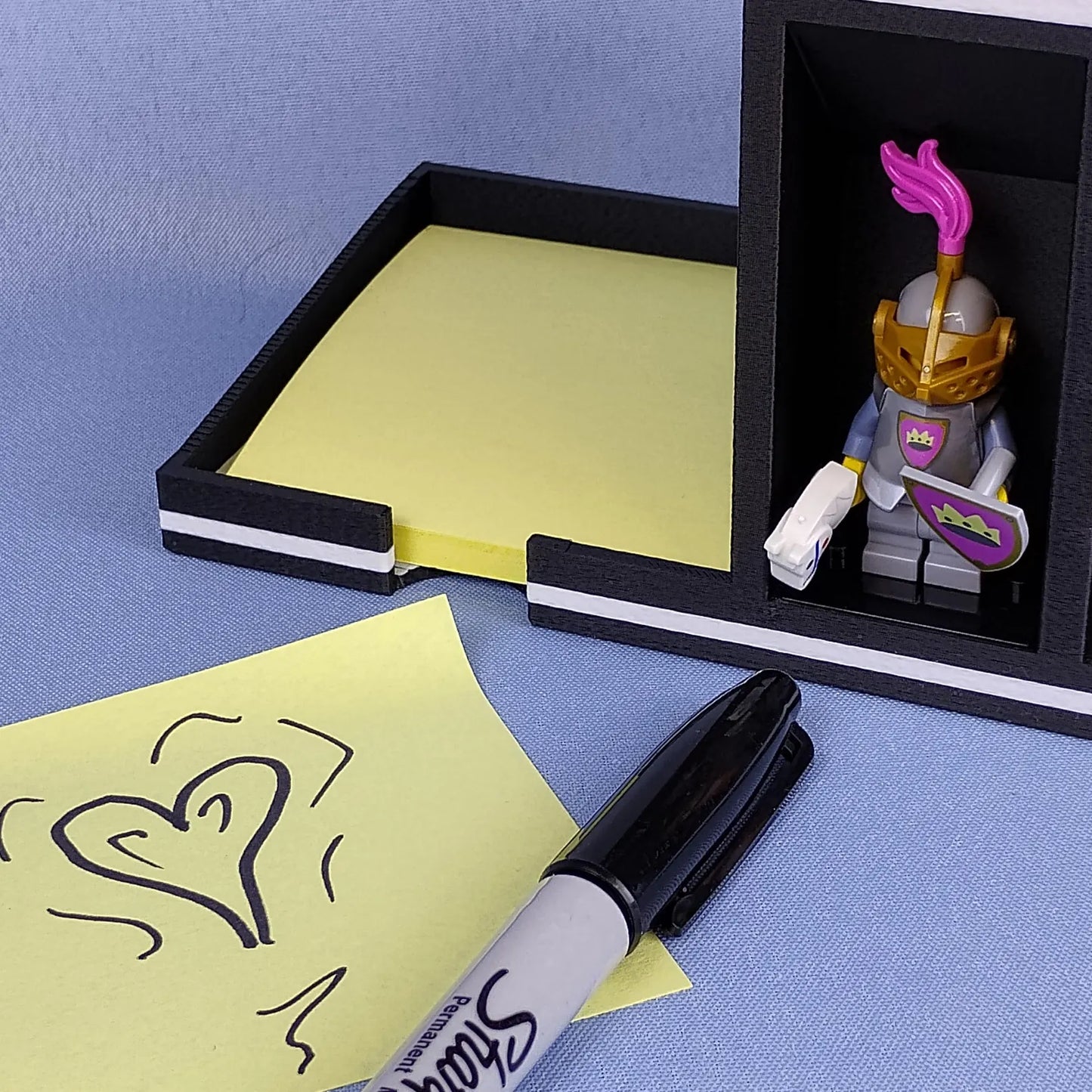 Post-it Note holder with LEGO® minifigure display spot and sticky notes shown with a marker
