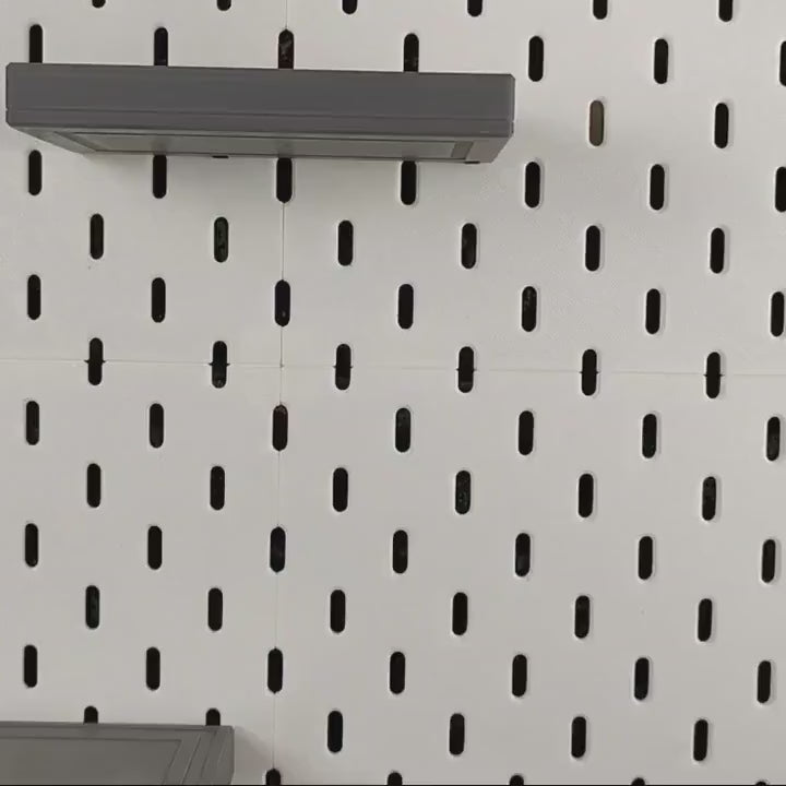 Product video thumbnail showing SKADIS floating shelves mounted on pegboard