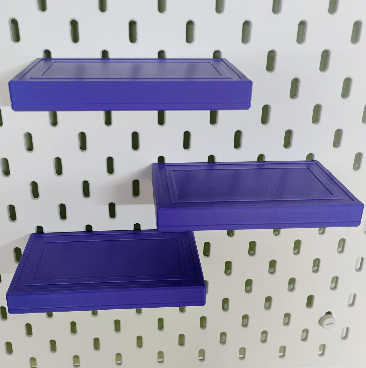 Purple floating shelves mounted on IKEA SKADIS pegboard for compact storage