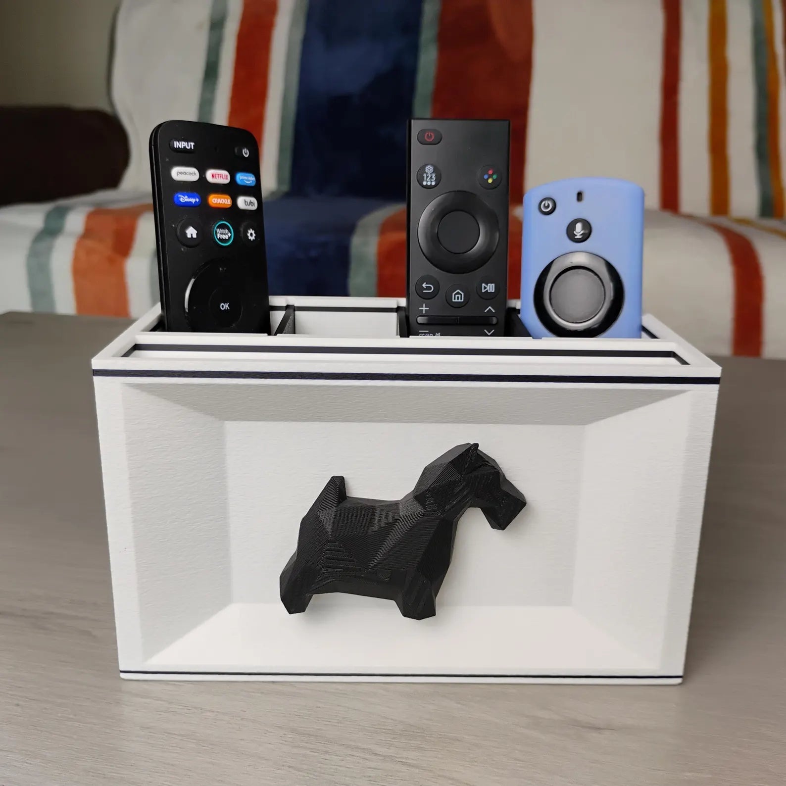 White Scottish Terrier remote holder on a tabletop holding remotes and small electronics
