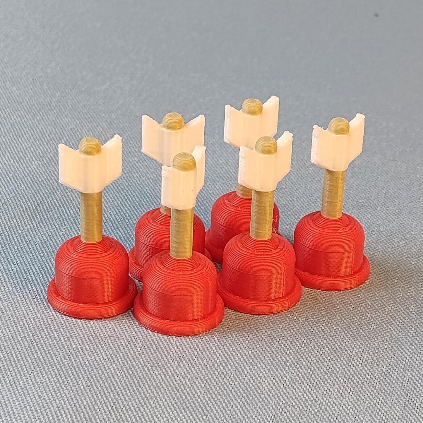 Set of mini Cupid arrow fridge magnets standing together with red plunger bases, gold shafts, and white arrow tips.