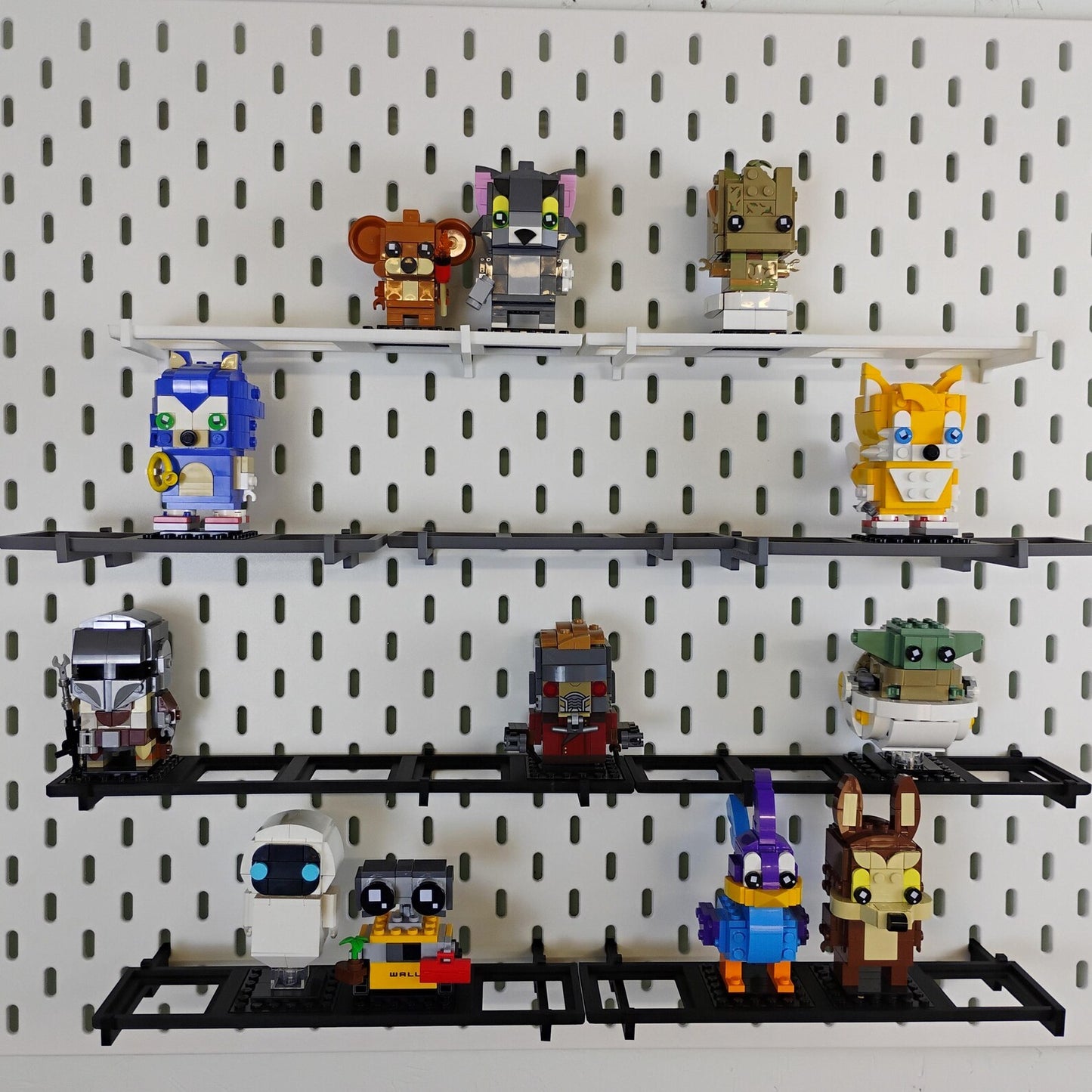 Overview of a SKÅDIS pegboard wall with multiple black shelves displaying LEGO® BrickHeadz™ figures in a vertical layout.