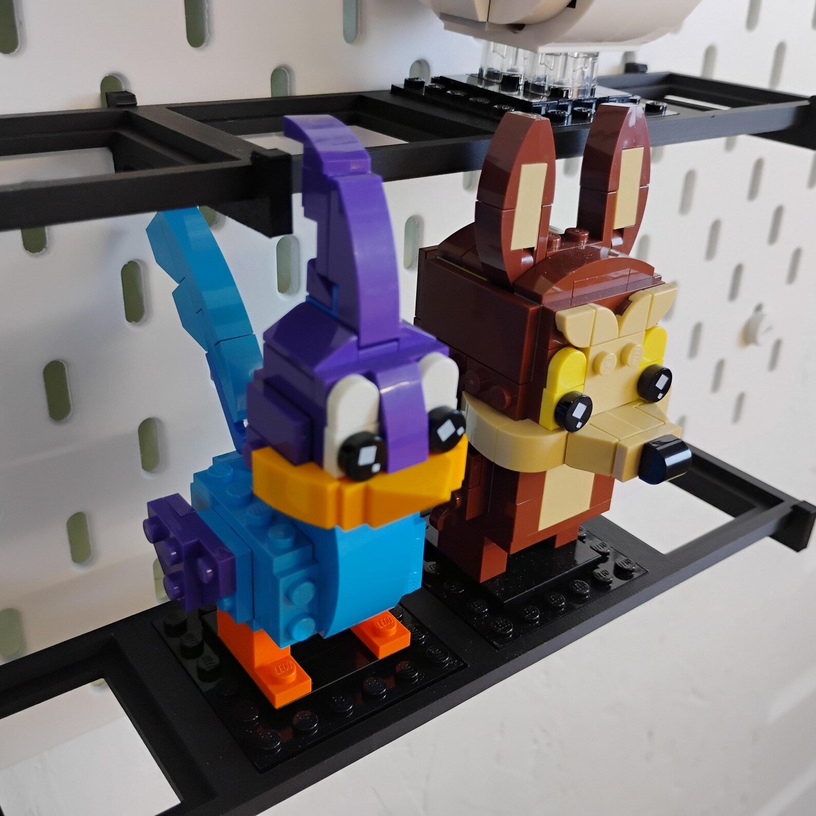 Close-up of LEGO® BrickHeadz™ figures displayed on a black SKÅDIS-compatible shelf mounted to an IKEA pegboard.