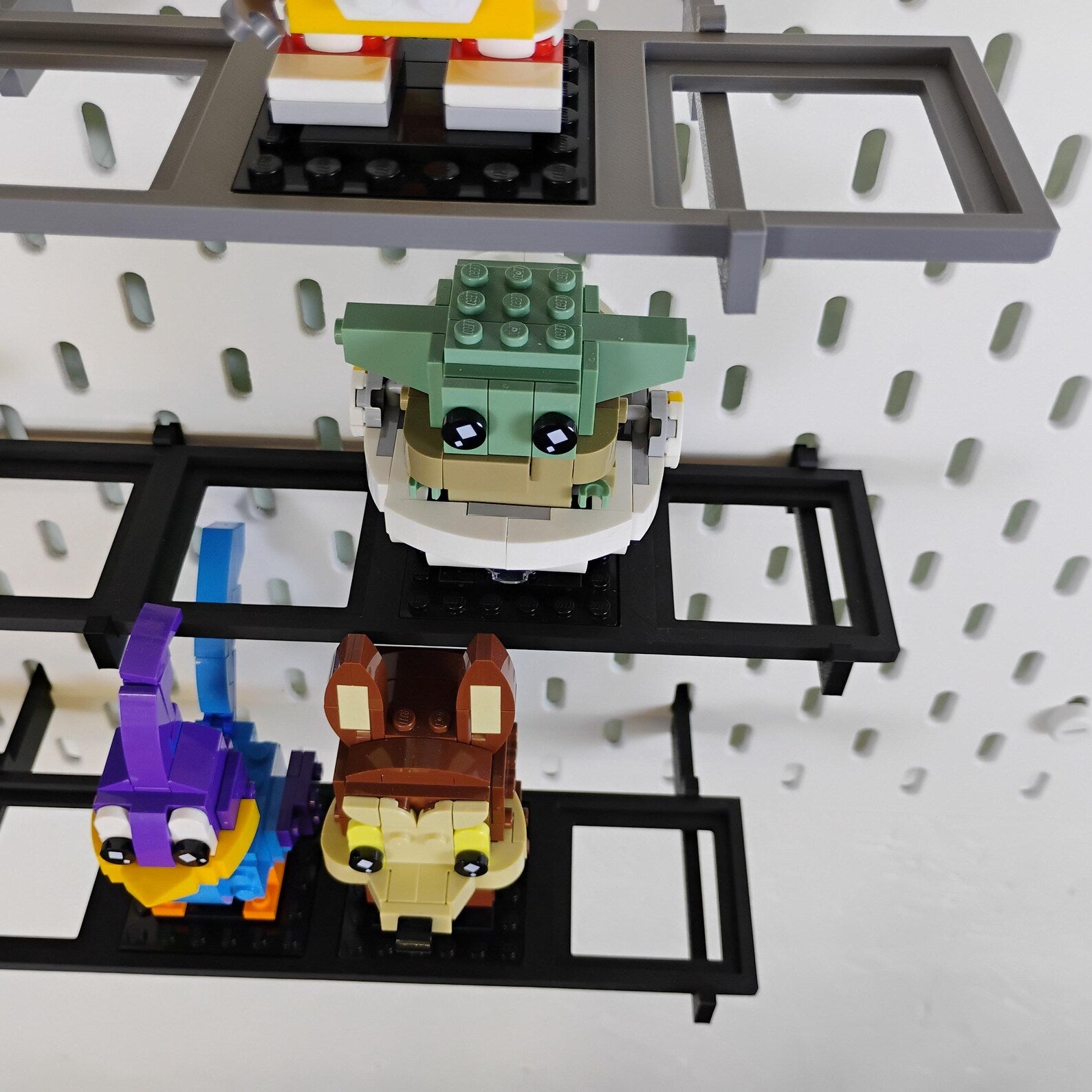 SKÅDIS-compatible BrickHeadz™ shelf setup showing extra-deep support pins for figures with bulky back details or overhangs.