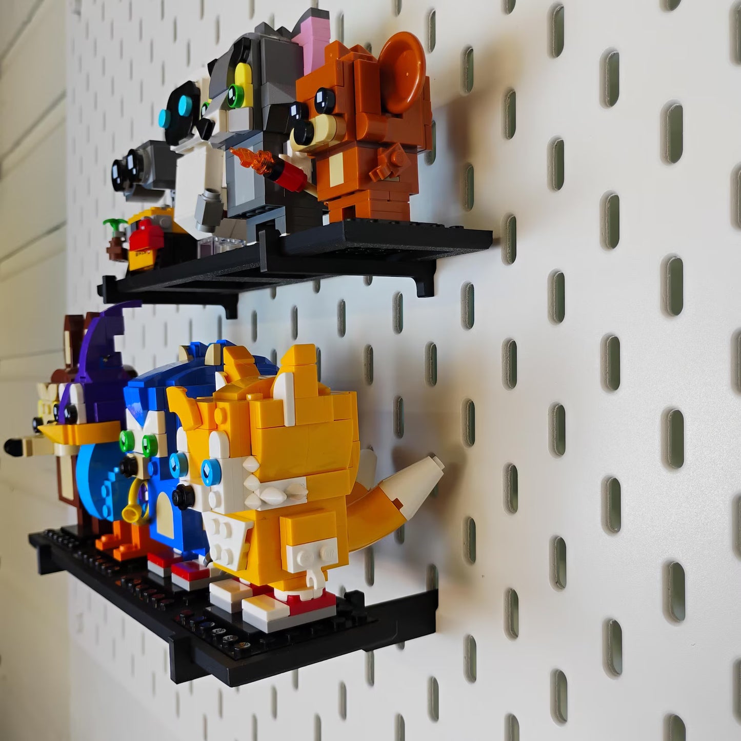 Angled view of SKÅDIS-compatible BrickHeadz™ shelves with multiple LEGO® figures displayed vertically on a pegboard.