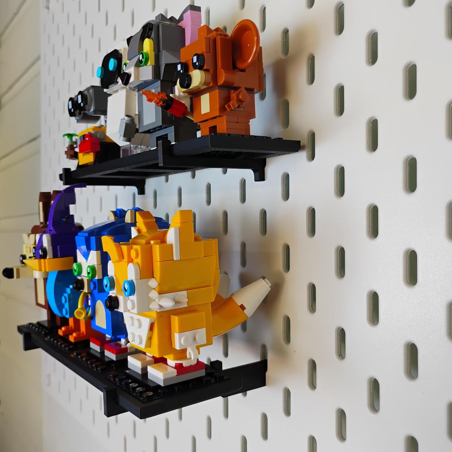 Angled view of SKÅDIS-compatible BrickHeadz™ shelves with multiple LEGO® figures displayed vertically on a pegboard.