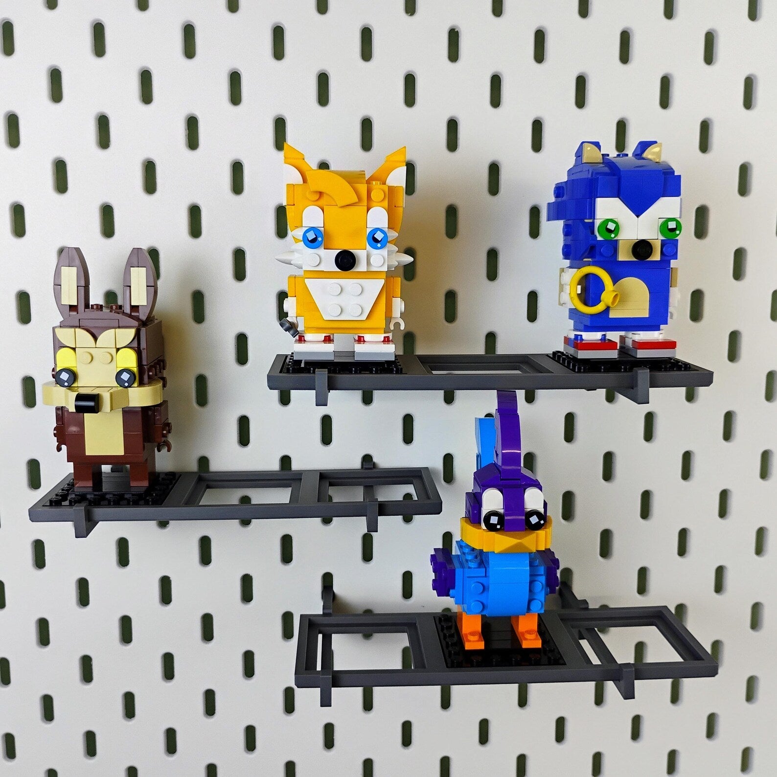Mixed-width SKÅDIS-compatible shelves displaying LEGO® BrickHeadz™ figures on an IKEA pegboard collector wall.