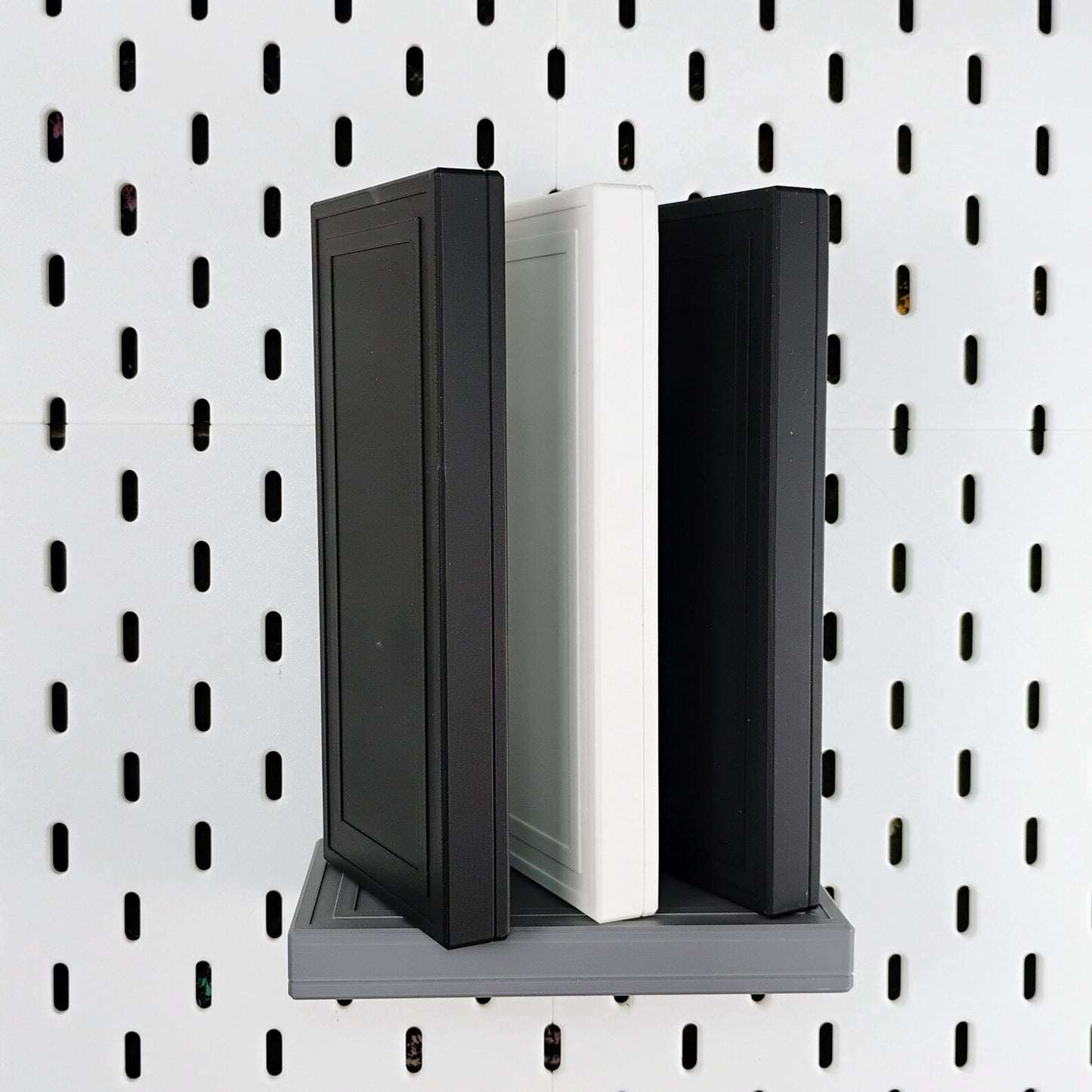 Gray floating shelf for IKEA SKADIS pegboard holding books with hidden support design