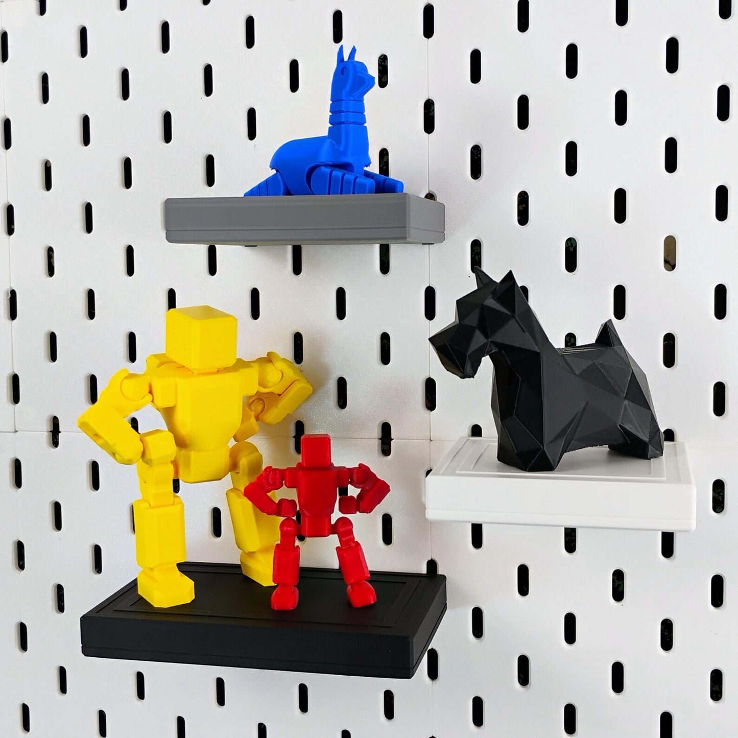 Black and blue SKADIS shelves displaying small LEGO® figures and decor pieces