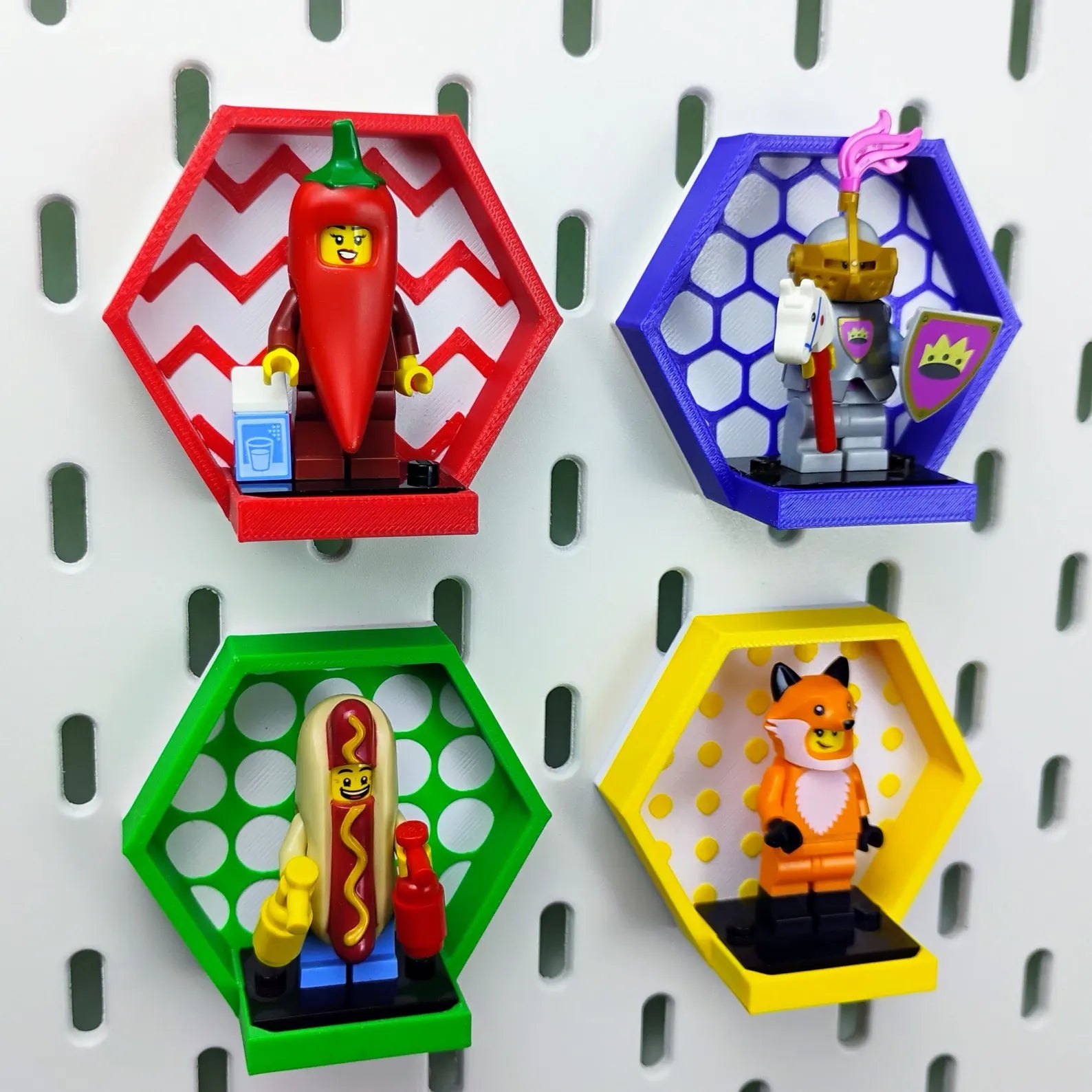 Colorful SKÅDIS-compatible hexagon minifigure displays mounted on an IKEA pegboard, shown with LEGO® minifigures and patterned backgrounds.