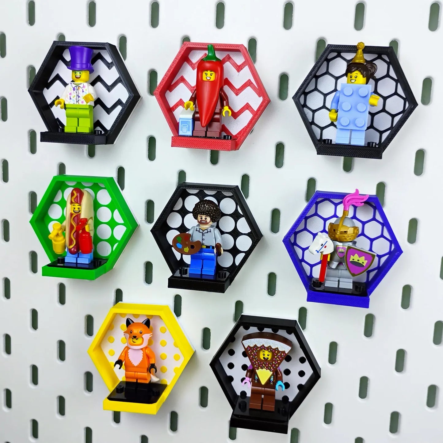 Larger SKÅDIS pegboard display wall with multiple hexagon minifigure frames in colorful and black options arranged together.