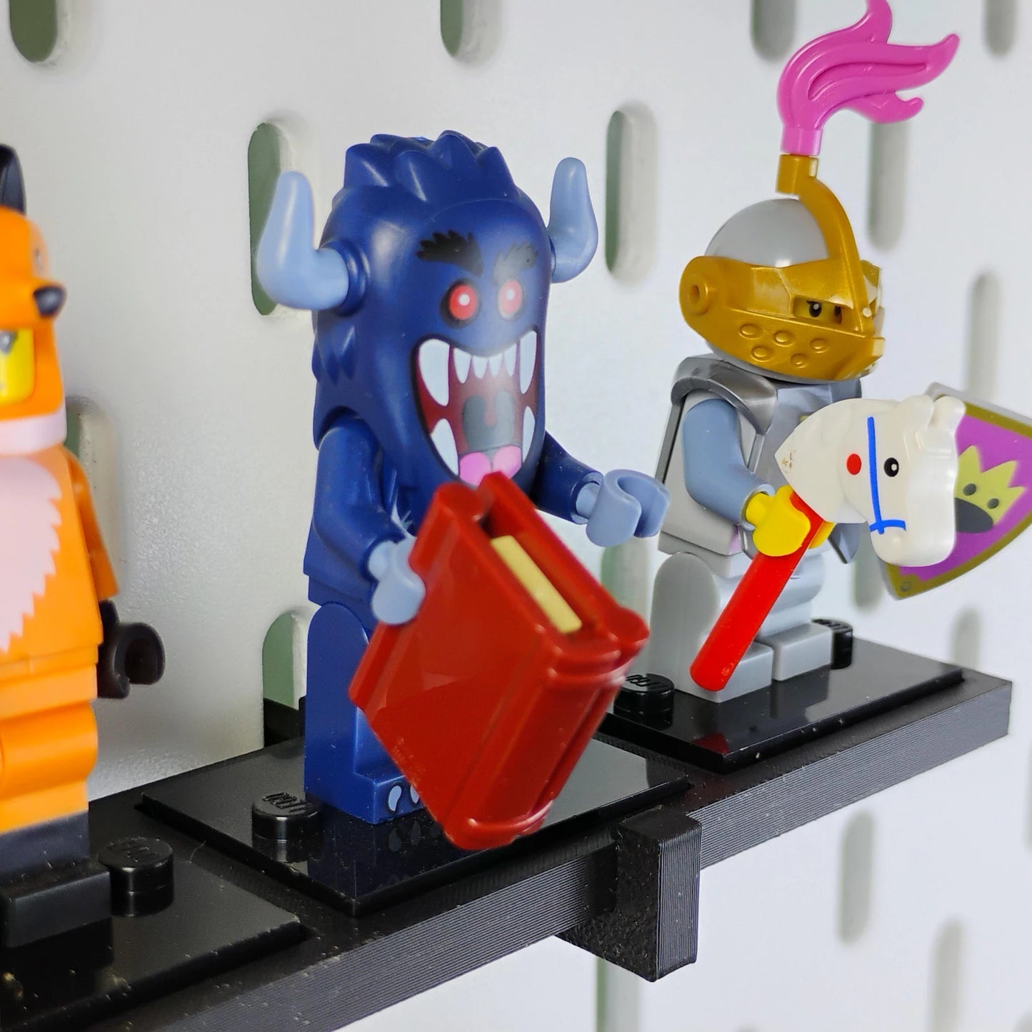 Close-up of LEGO® minifigures standing on a black SKADIS compatible display shelf