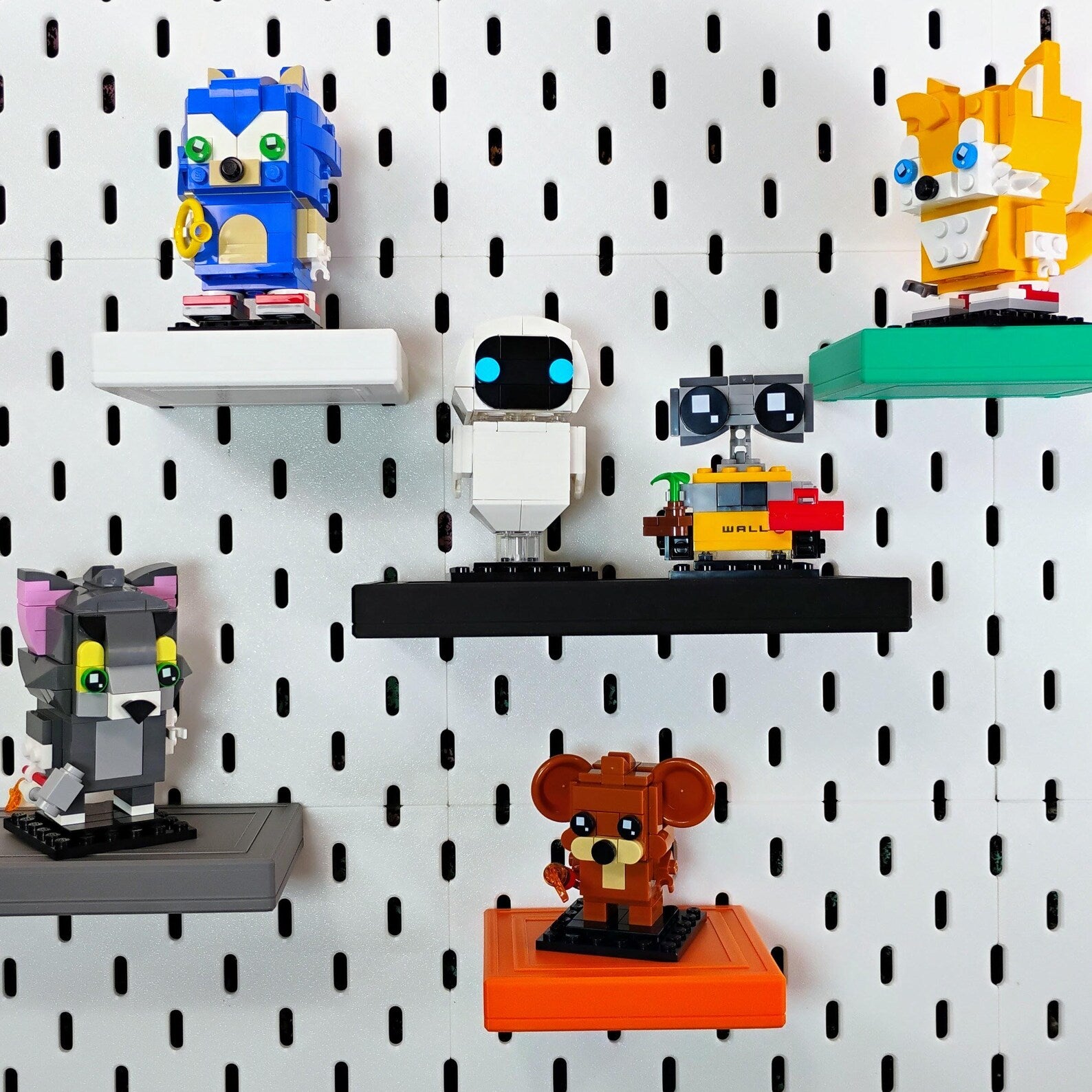 Colorful SKADIS shelves displaying small collectible figures and desk decor
