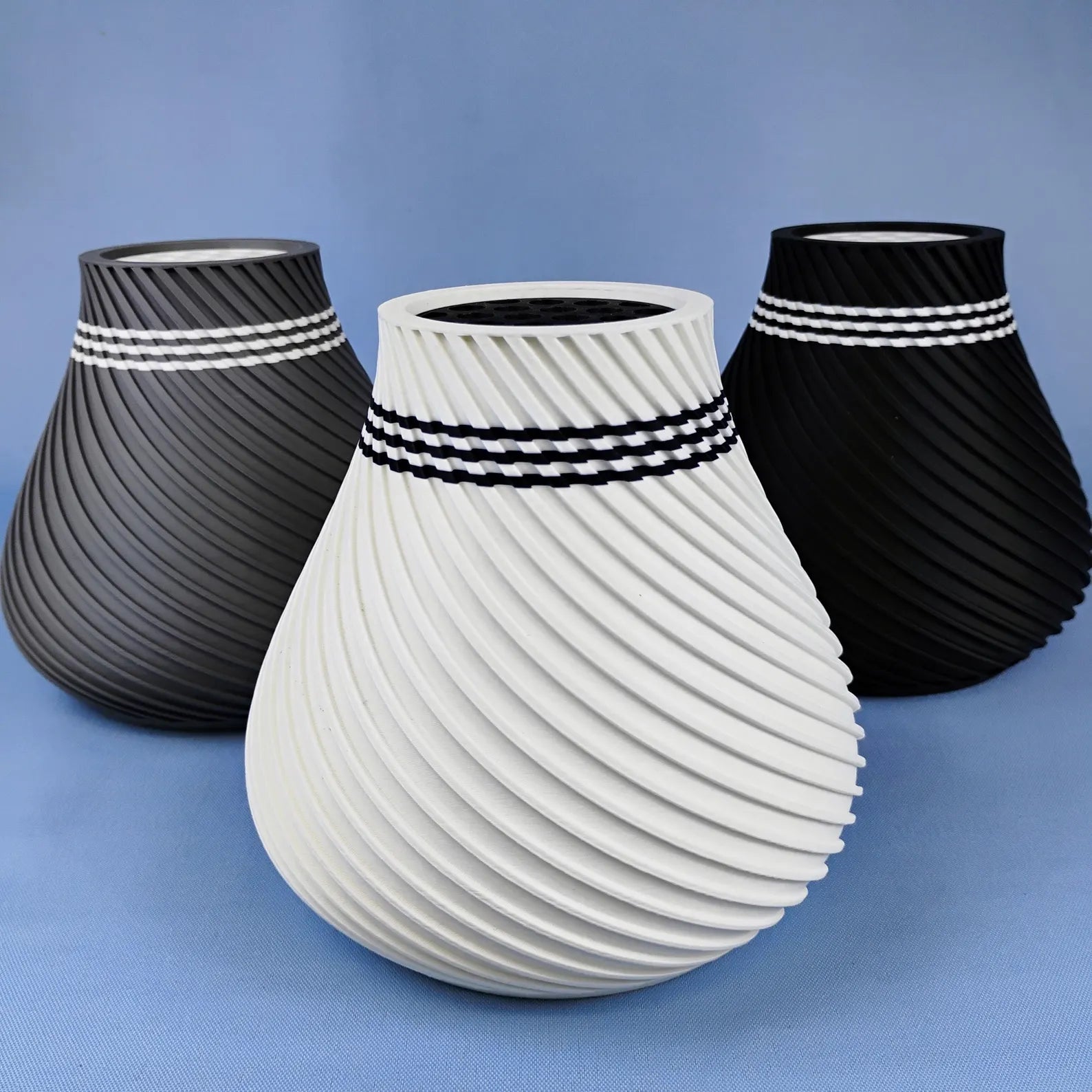 Empty swirly vases in gray, white, and black shown as modern decorative display options