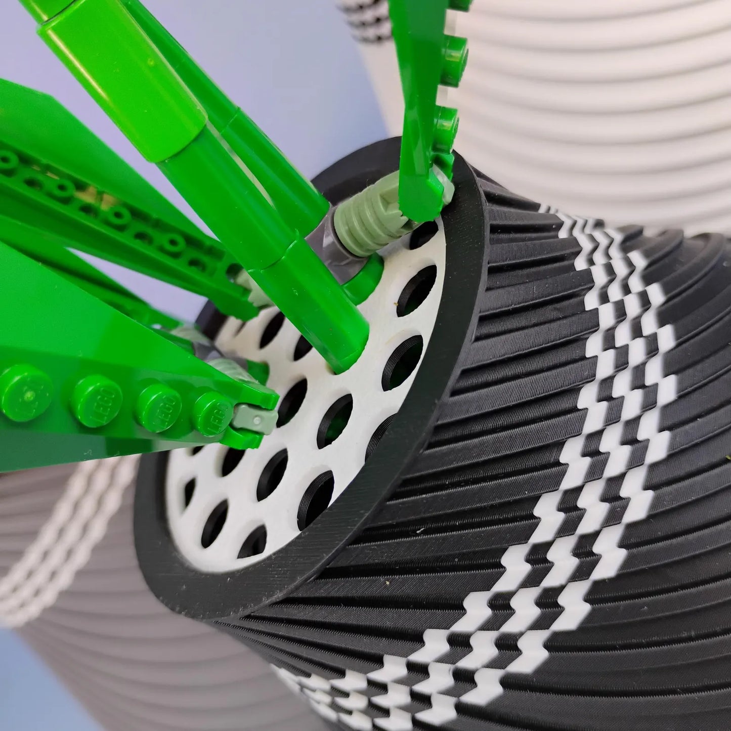 Close-up of LEGO® botanical stems placed into the removable grid insert of a swirly vase