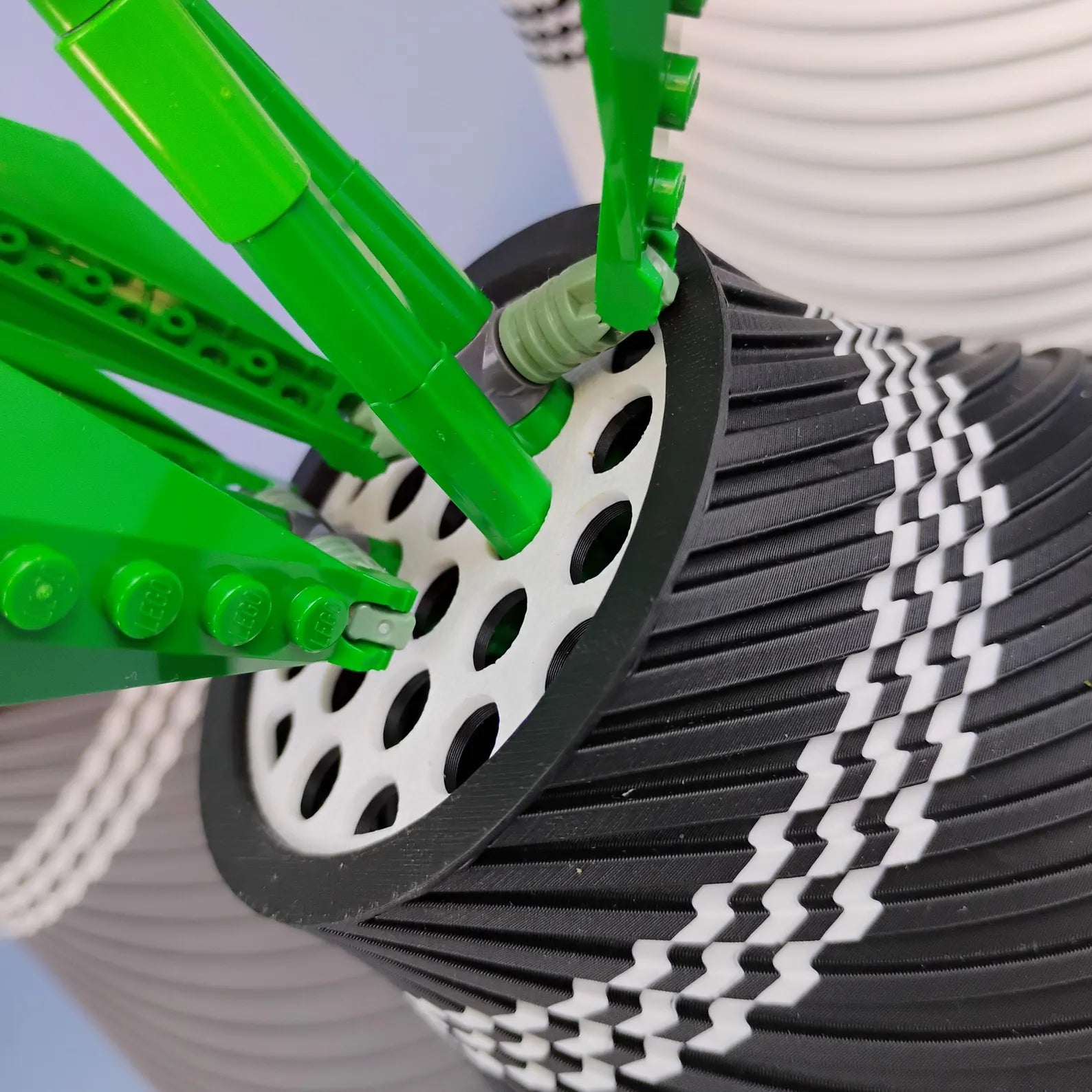 Close-up of LEGO® botanical stems placed into the removable grid insert of a swirly vase