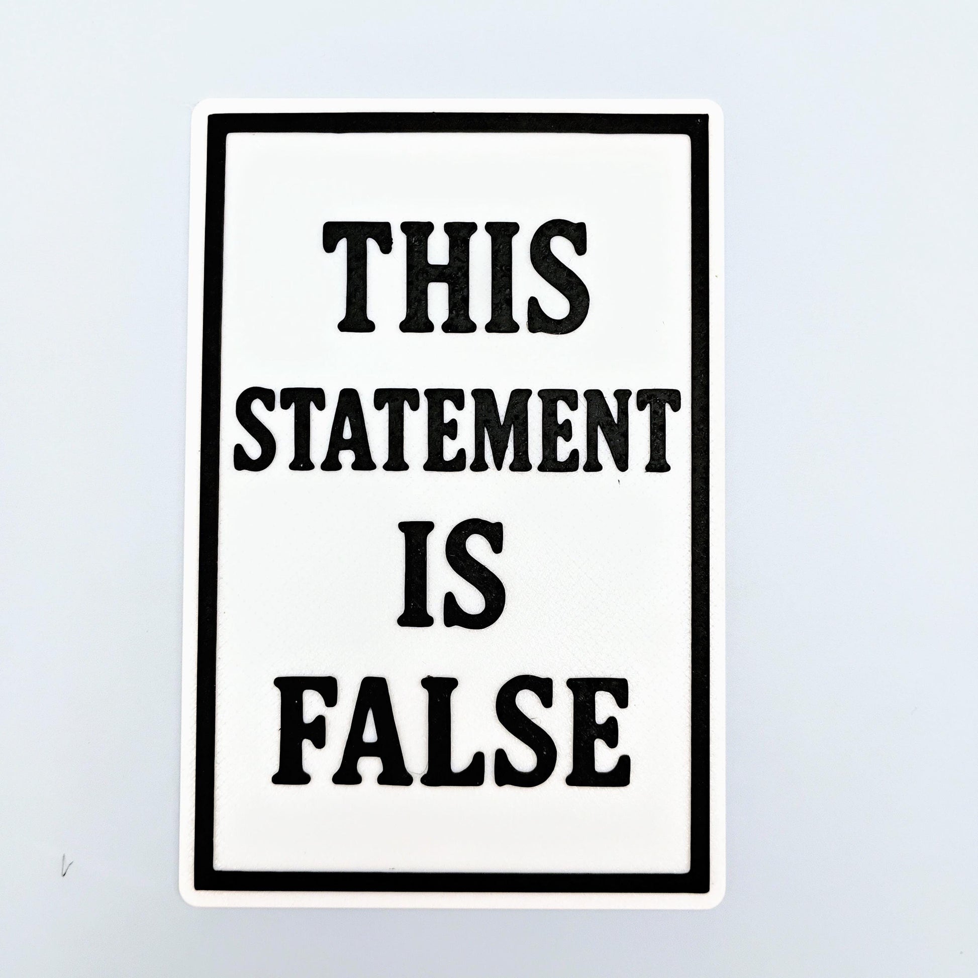 This Statement Is False paradox sign with bold black text on a white background