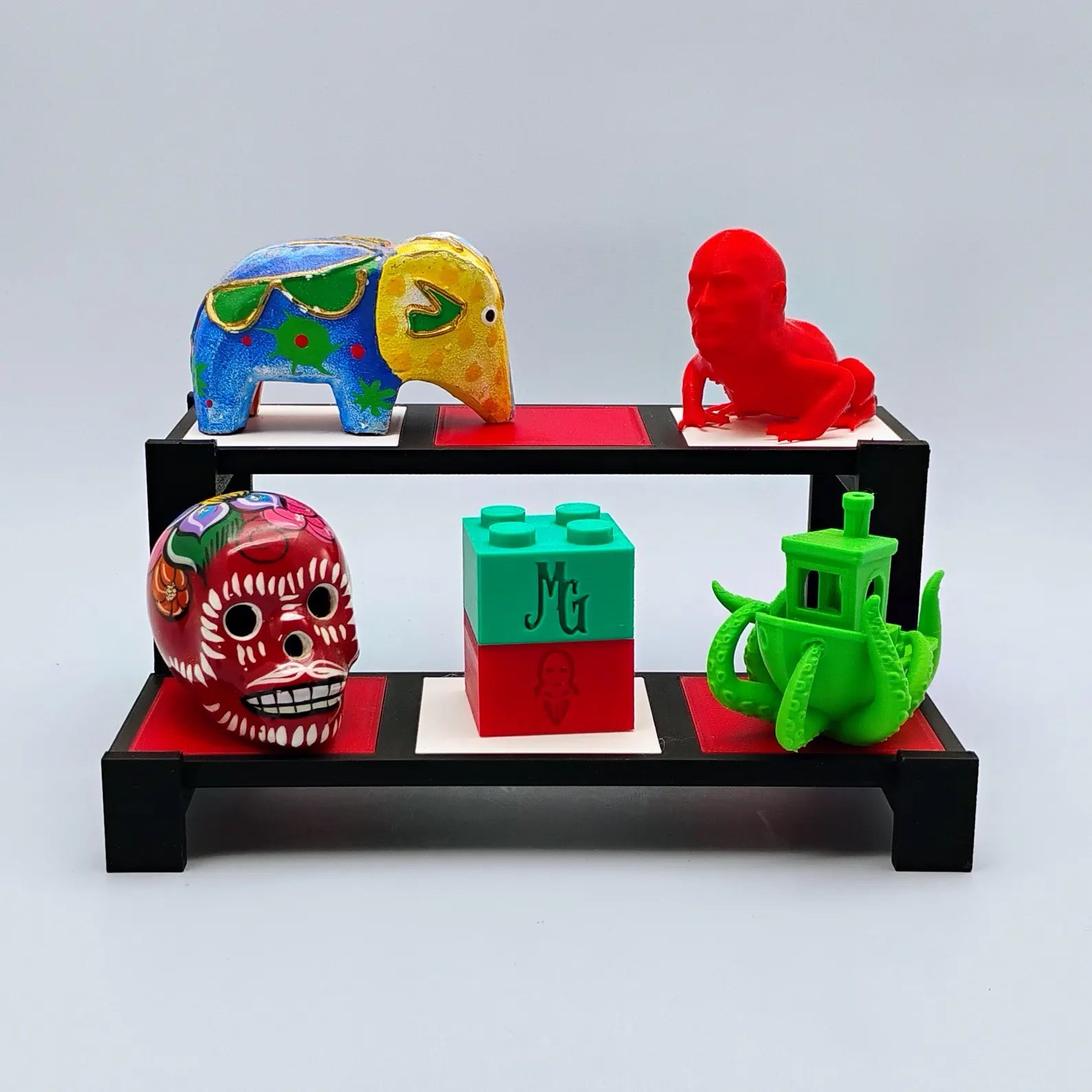 Tiered display stand for Funko Pops, trinkets, crystals, mini figures, and collectibles with black frame and red, white, and black tiles.