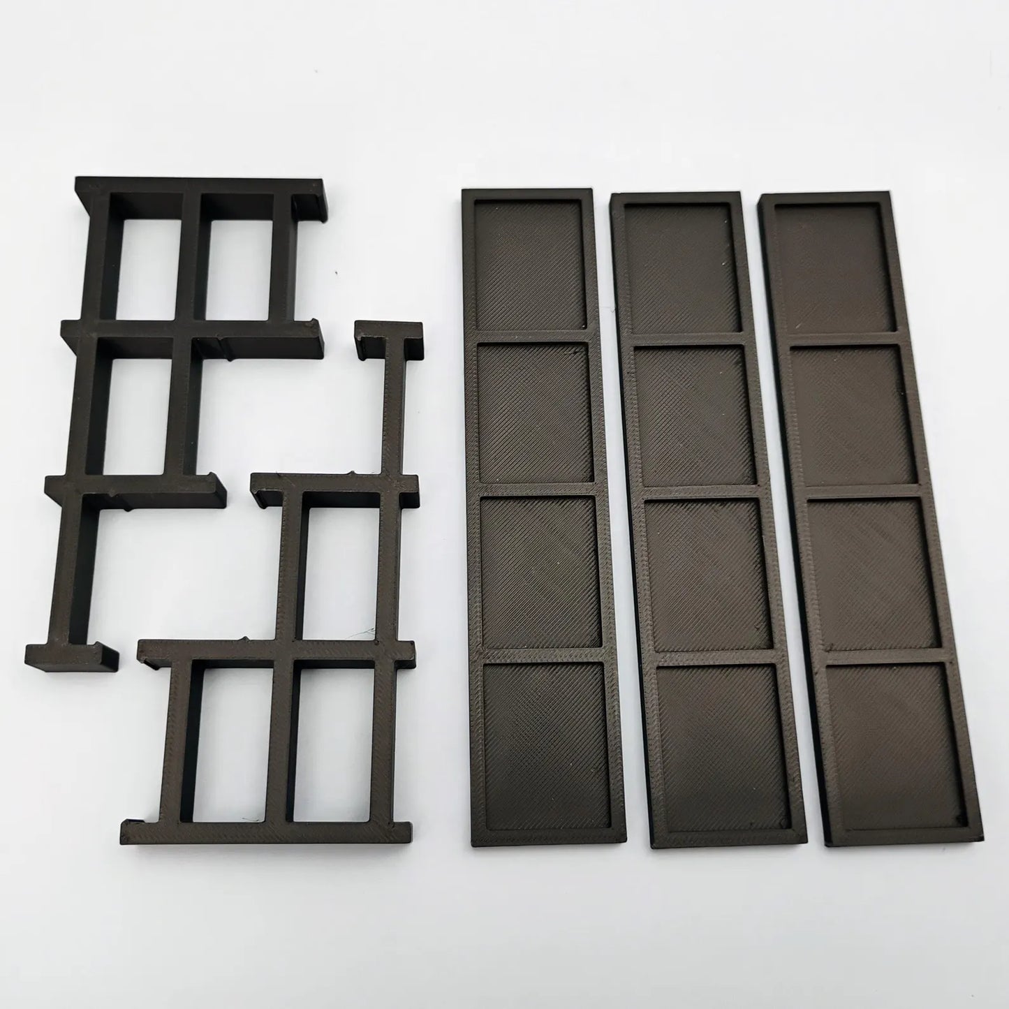Tiered minifigure display stand shown disassembled with side supports, shelves, and rear support pieces.