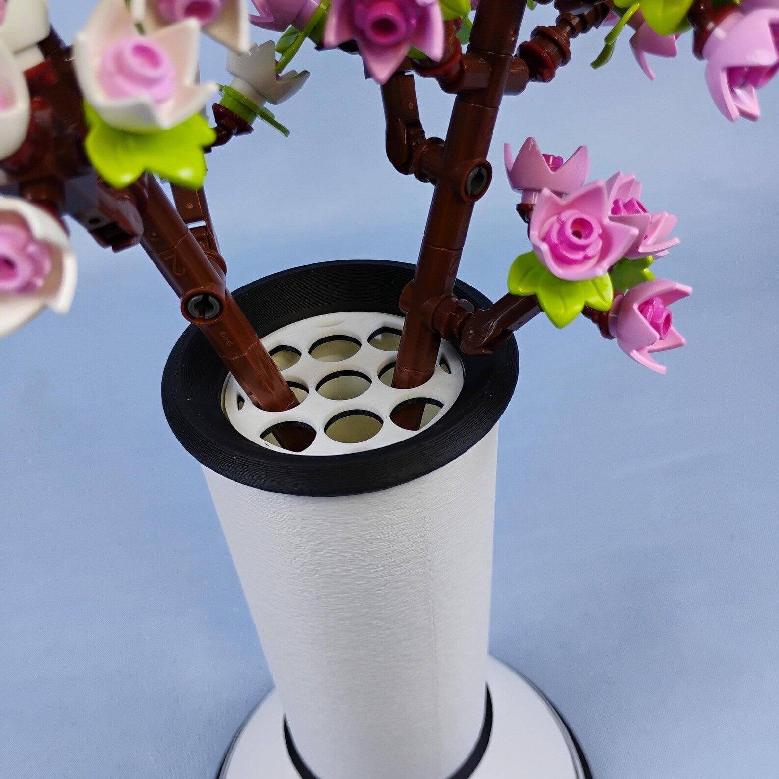 White minimalist vase with LEGO® cherry blossom stems placed into the removable grid insert