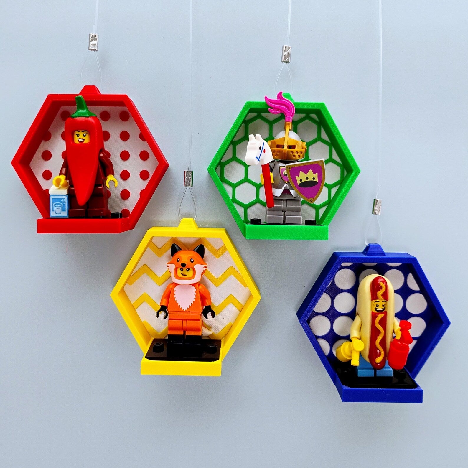 Set of colorful window-hanging displays for LEGO® minifigures with suction cup lines, patterned backgrounds, and 3x4 figure plates.