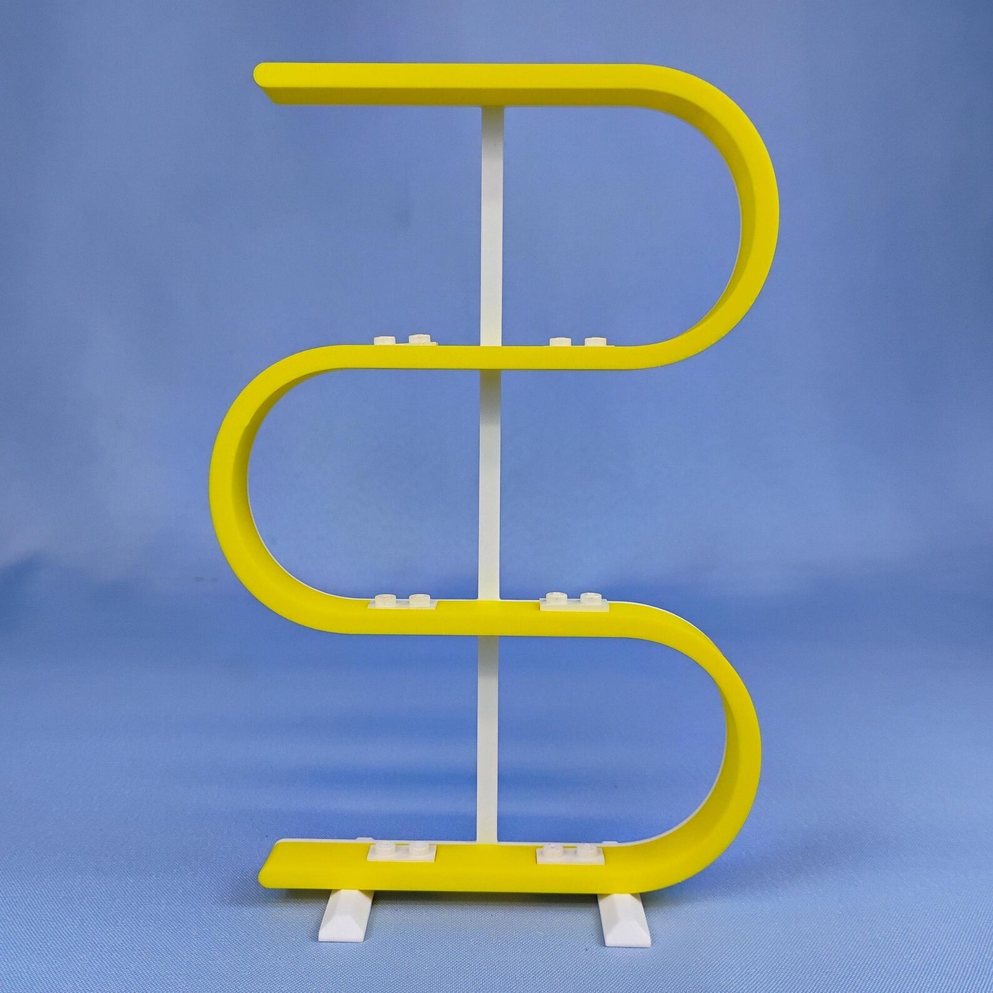 Empty yellow squiggle display stand for LEGO® minifigures on a blue background